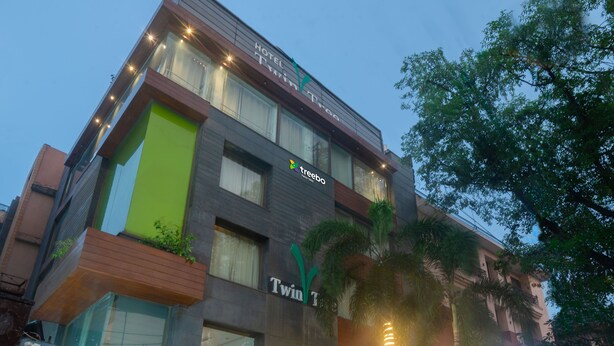 Um edifício moderno de hotel com uma placa indicando 'Twin Tree Hotel'.