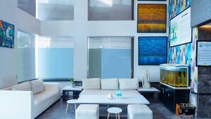 Uma sala moderna com um sofá, uma mesa de centro e um aquário.