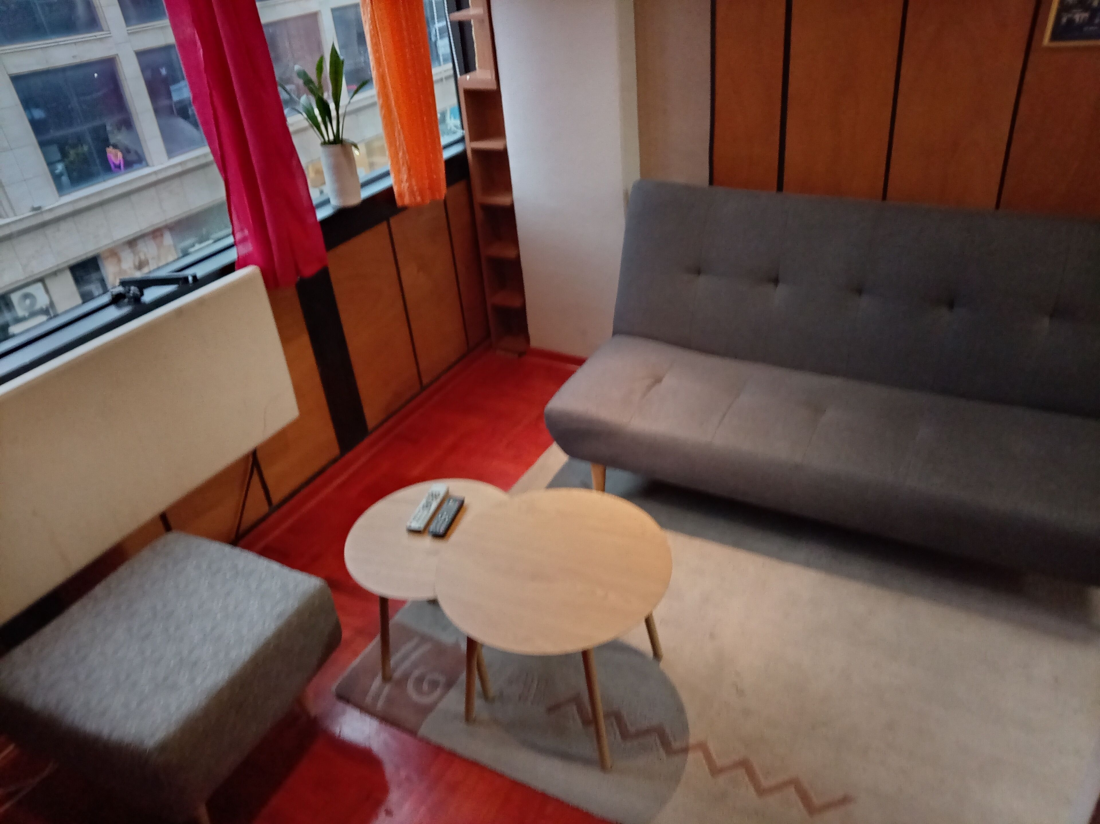 A modern living room with a grey sofa, a small round coffee table, and a grey armchair.