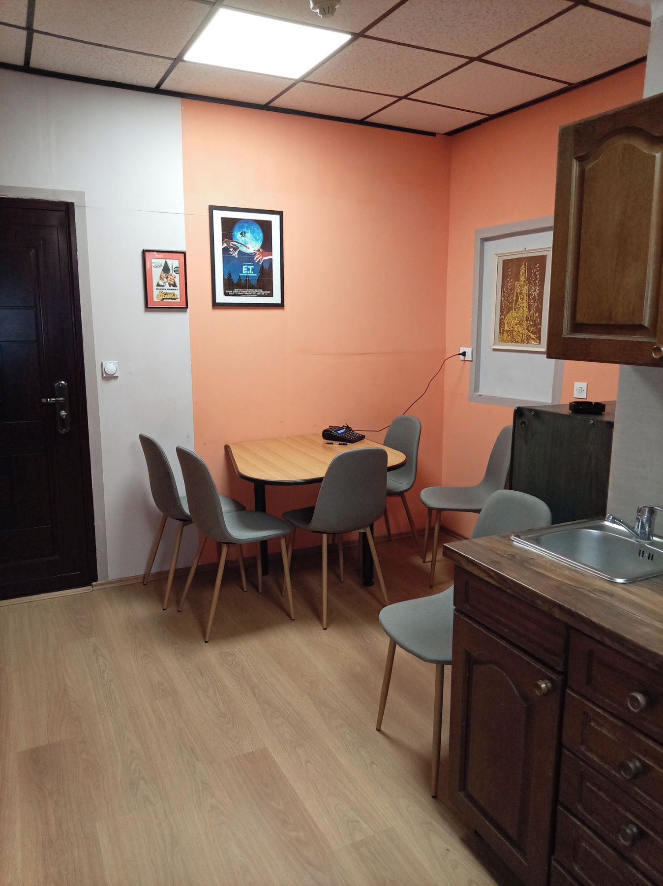 Une pièce avec une table et des chaises en bois, un évier et un placard.