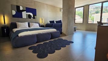 Un dormitorio moderno con una cama grande, un escritorio y vistas al exterior.