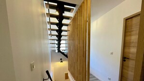 Un escalier avec des rampes en bois et un luminaire moderne.