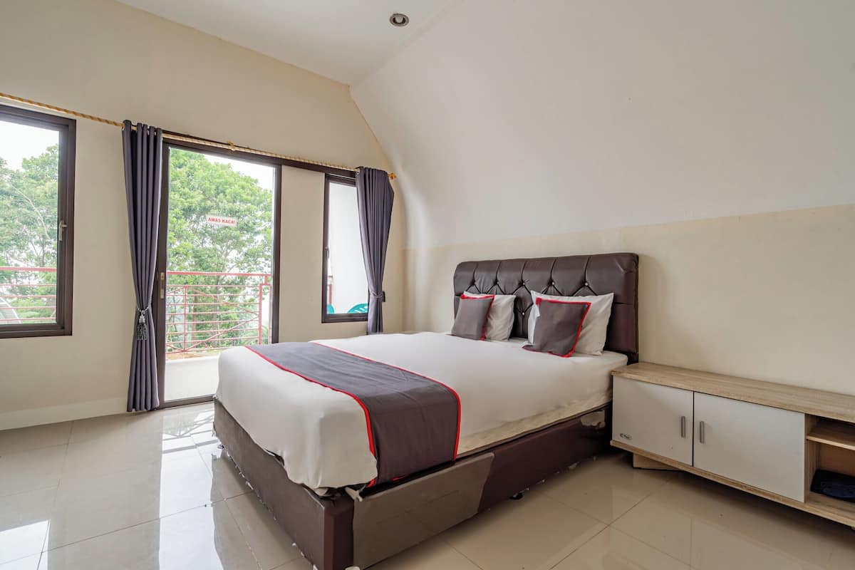 A bedroom with a bed, a nightstand, a wardrobe, and a sliding glass door leading to a balcony.