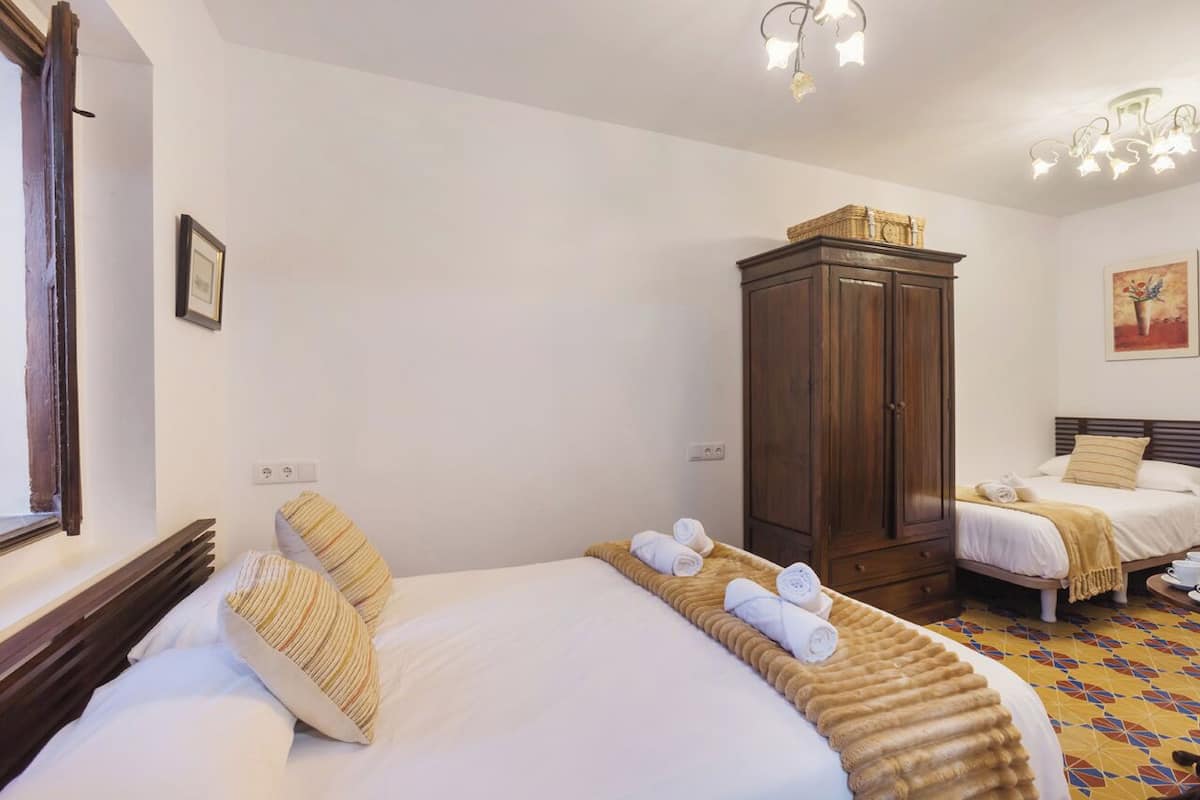 Een hotelkamer met twee bedden, een kledingkast en een raam.