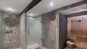 A modern bathroom with a glass-enclosed shower, a wooden sauna, and a clock on the wall. - La Casona de las Flores (Ondara)