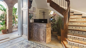 A staircase with a wooden handrail and a patterned floor. - La Casona de las Flores (Ondara)