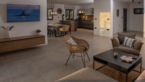 Un salon moderne comprenant un canapé, une table basse et un coin repas avec une table et des chaises.