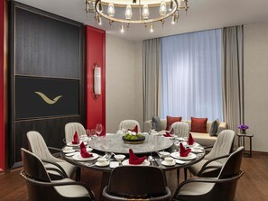 A dining area with a round table set for six, surrounded by chairs. - Movenpick Qingdao Sunmei (Qingdao)