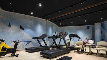 A modern gym with treadmills, a stationary bike, and a bench.