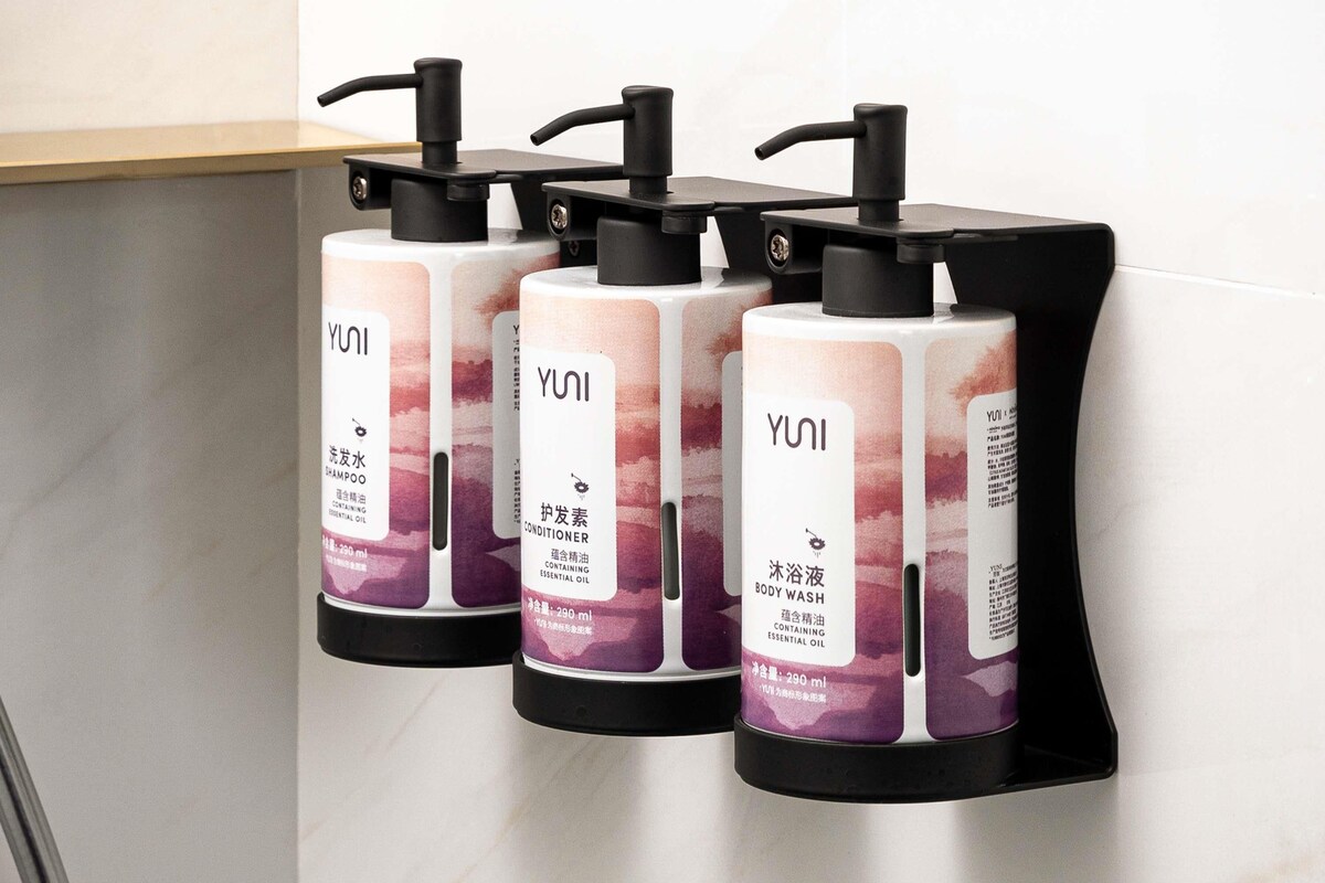 Three YUNI body wash dispensers mounted on a wall.
