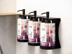 Three YUNI body wash dispensers mounted on a wall. - Movenpick Qingdao Sunmei (Qingdao)