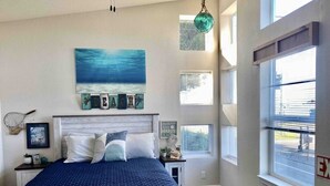 A bedroom with a bed, a painting, and a window. - 🛟🎣😎Harbor Lite 2BdrmDreamHouse +Loft! AT the PORT. Peeks of Harbor,River,Ocean! (Brookings)
