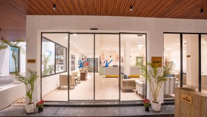 A reception area with a modern design, featuring a reception desk, seating area, and potted plants. - Velmore Kasauli Operated by Royal Orchid (Kasauli)