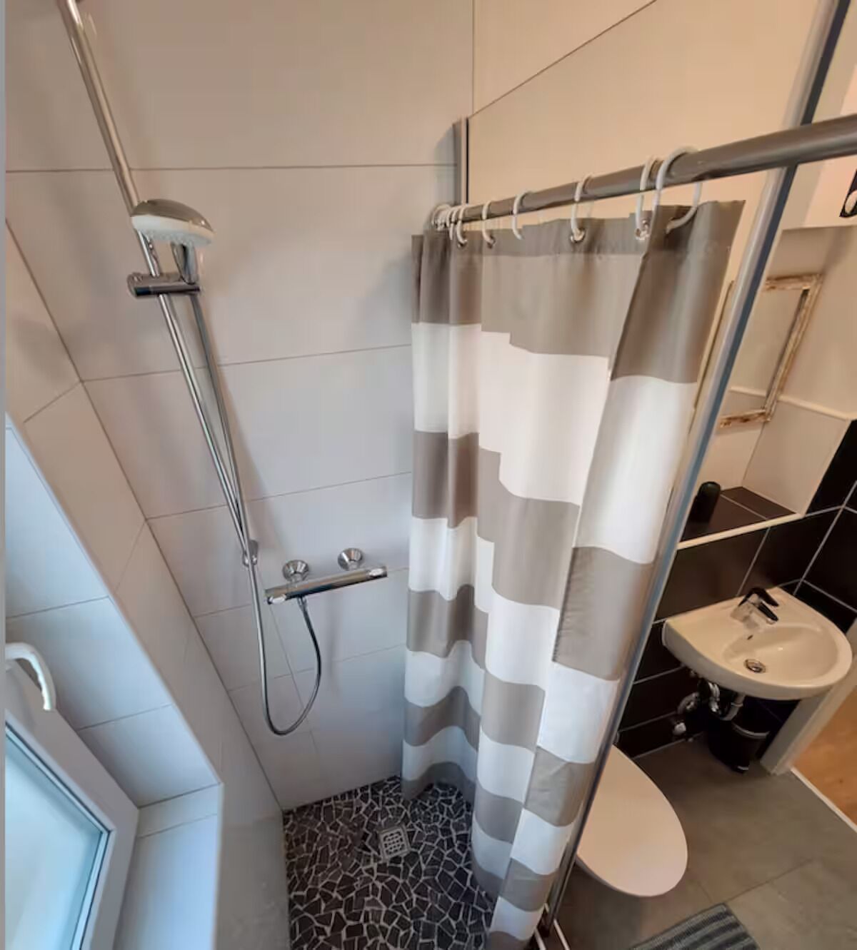 Un baño con ducha, inodoro y lavamanos.