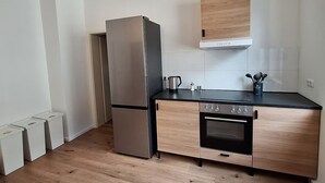 Una cocina moderna con un refrigerador de acero inoxidable, un horno empotrado y una encimera de madera.