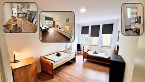 Ein kleines Zimmer mit Holzboden, einem Bett, einem kleinen Schreibtisch, einem Stuhl und einem Fenster mit Jalousien.
