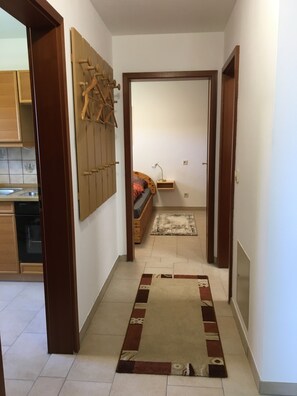 Enter a serene bedroom with a comfortable bed, bedside table, and window with blinds.