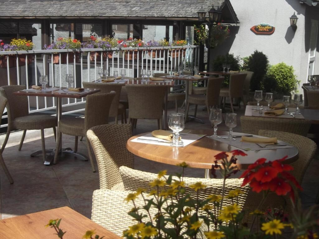 Un espace extérieur aménagé pour les repas, avec des meubles et des tables en osier.