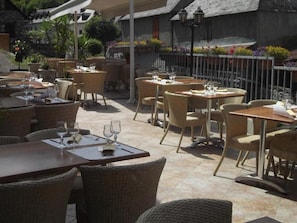 An outdoor dining area with wicker furniture and tables set for dining.
