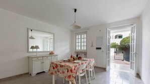 A dining area with a table set for four, a white cabinet, and a mirror on the wall. - 3725 Villino Marisun by Barbarhouse (Porto Cesareo)