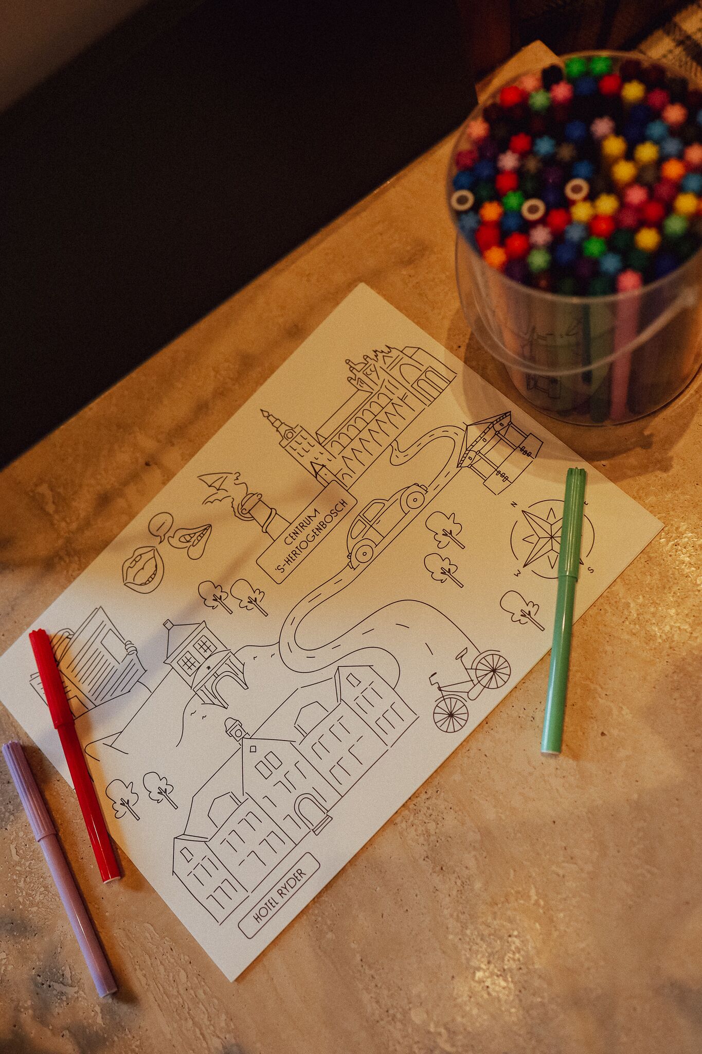 Un dibujo de un pueblo con puntos de referencia señalados, como 'CENTRUM' y 'Hôtel Ryder'.