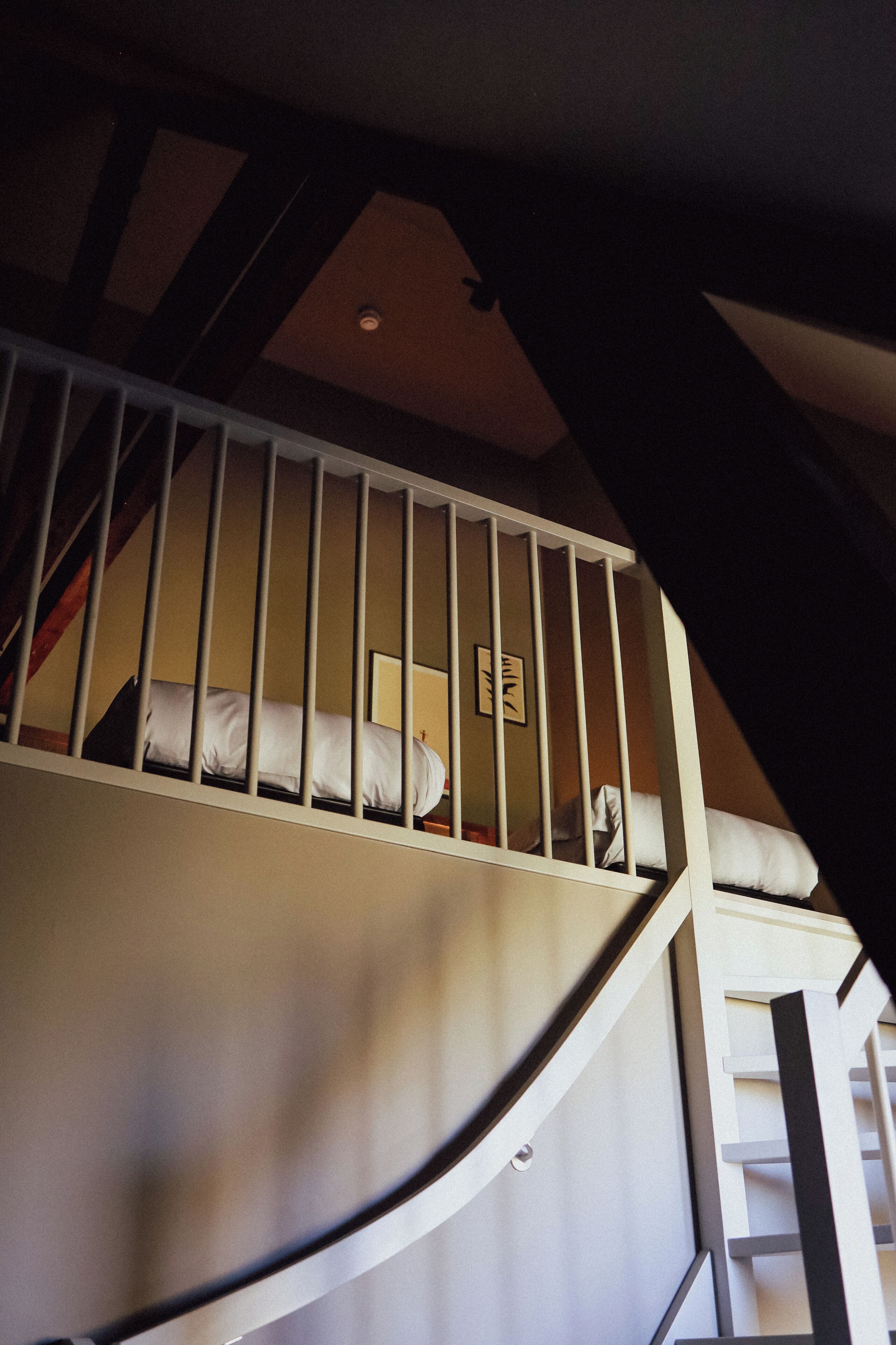 A bunk bed with a white railing, a ladder, and a headboard.