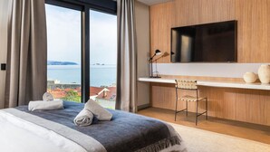 A modern hotel room with a large bed, a desk, and a TV. - Majestic Villa Lidija w/ private infinity pool and sea view  (Dubrovnik)