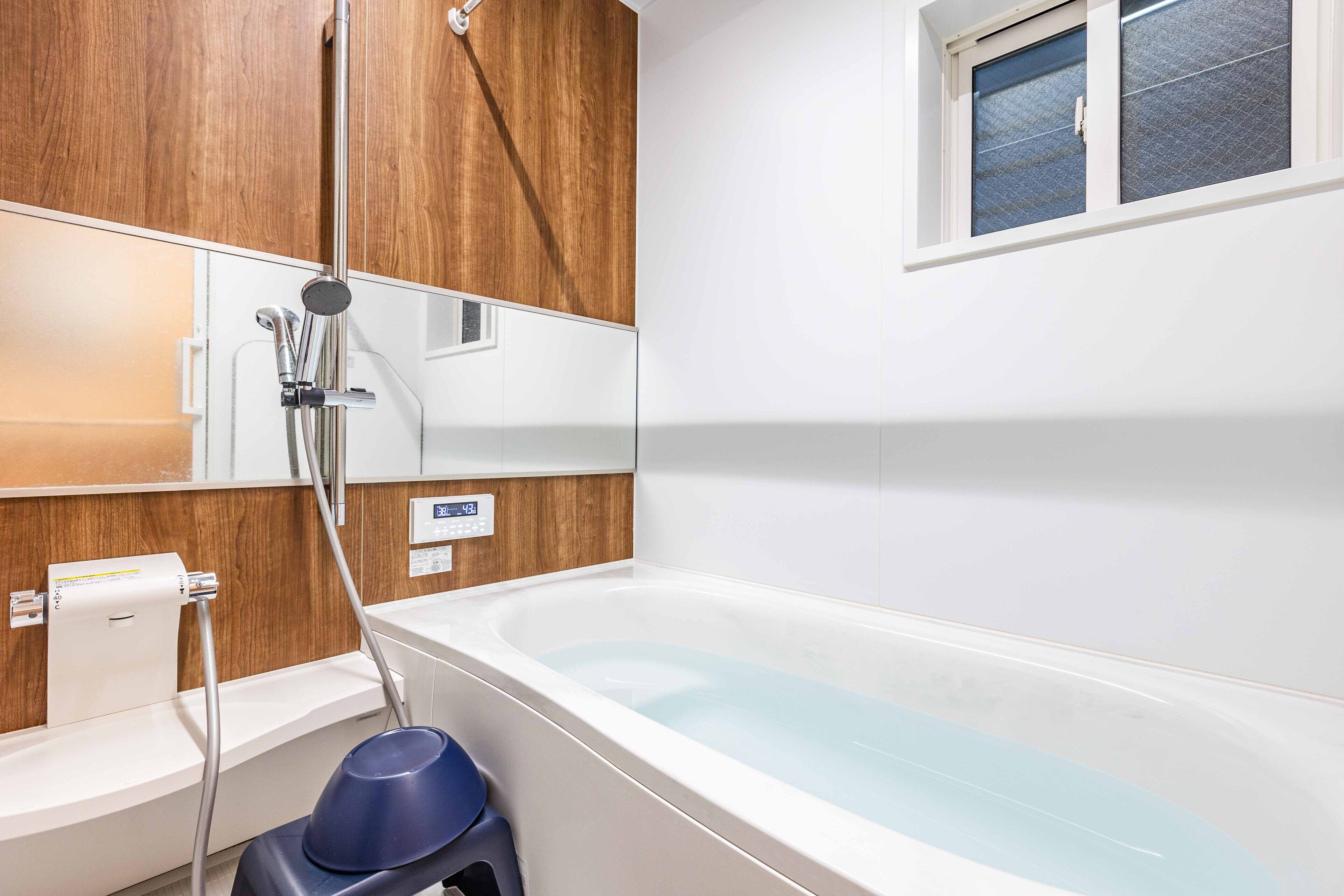 A modern bathroom with a bathtub, a shower, and a toilet.