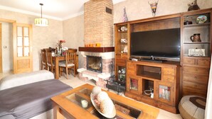 A living room with a fireplace, television, and wooden furniture. - 1020 Casa Pat (Nerja)
