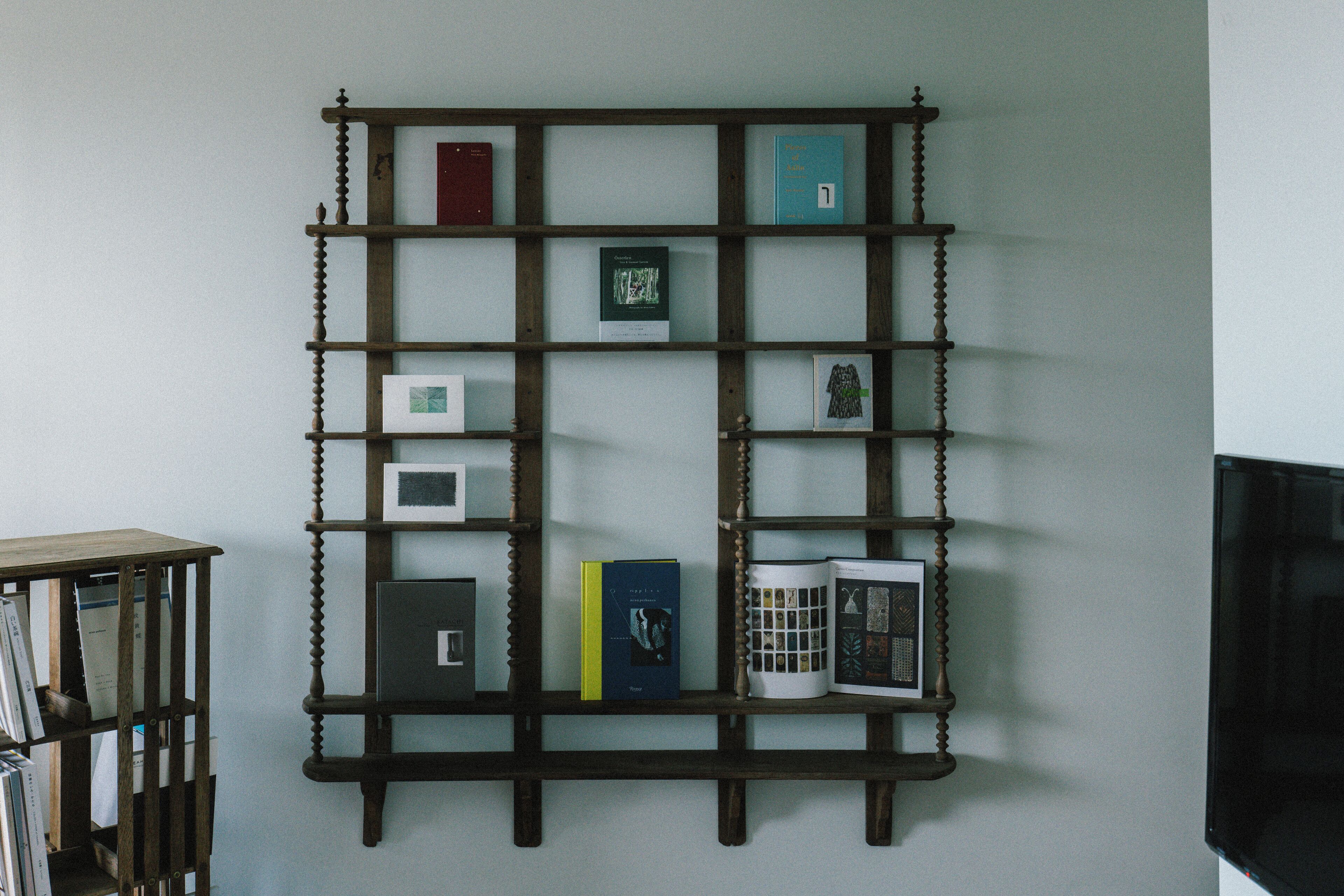 Una estantería de madera con varios libros y objetos decorativos.