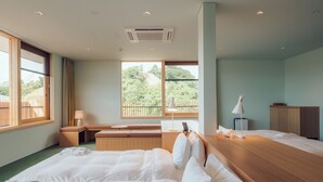 A hotel room with a large bed, a desk, a chair, and a view of a balcony with trees. - Hatago VISON (Taki)
