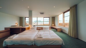 A hotel room with a large bed, a desk, and a view of the water. - Hatago VISON (Taki)
