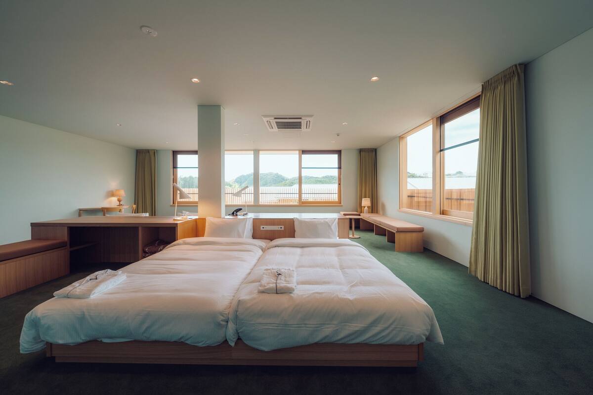 A hotel room with a large bed, a desk, and a view of the water.