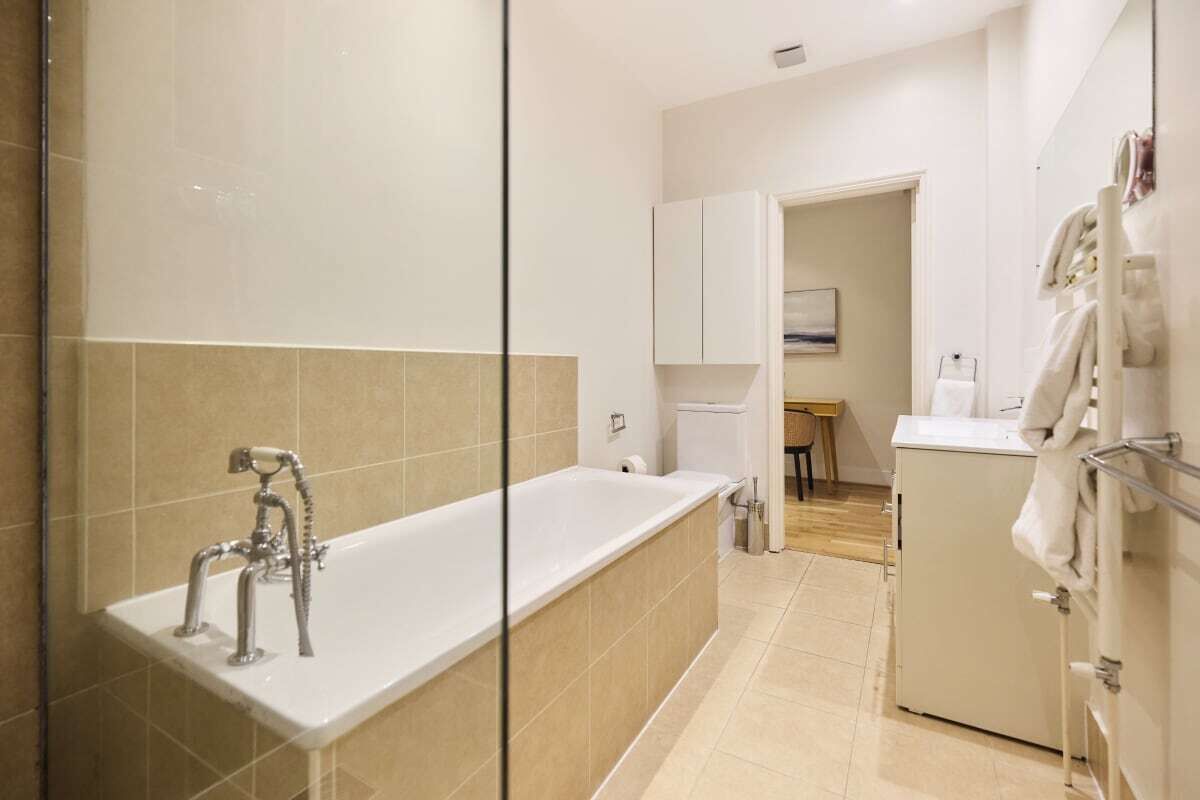 Une salle de bain moderne avec une grande baignoire, un espace douche et des toilettes.