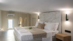 A modern bedroom with a large bed, bedside tables, and a view of the outdoors. - Deluxe Private Pool Villa, Elia Stone Villas (Thasos)
