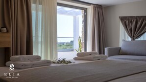 A hotel room with a bed, a sofa, and a window with curtains. - Premium Private Pool Villa, Elia Stone Villas (Thasos)