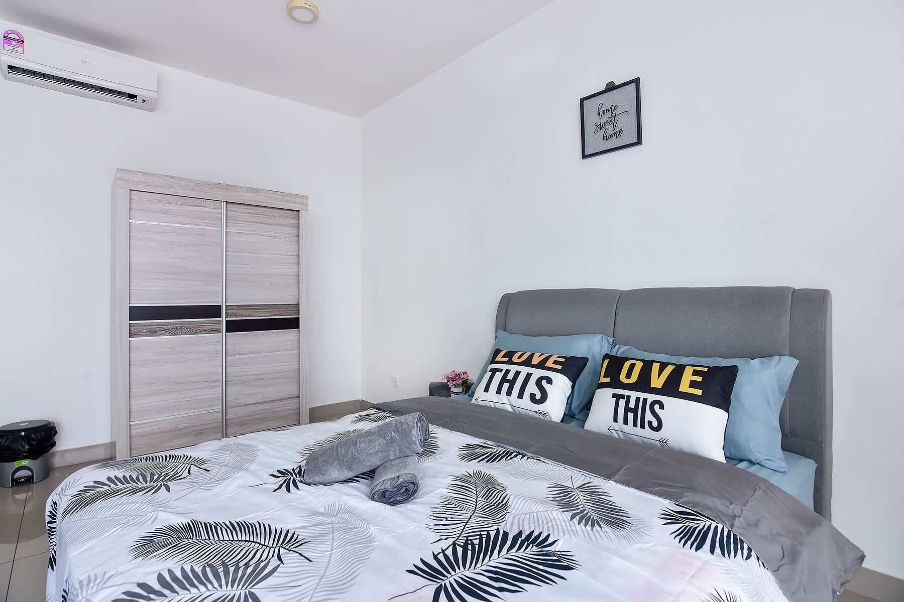Ein Schlafzimmer mit einem Bett, einem grauen Kopfteil, einem Kleiderschrank und einer Wand-Klimaanlage.
