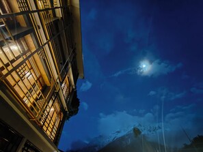 A building with traditional architectural style, featuring wooden lattice windows and a visible moon in the night sky. - Valmere Bayul Shangri-La Resort  (Chungthang)