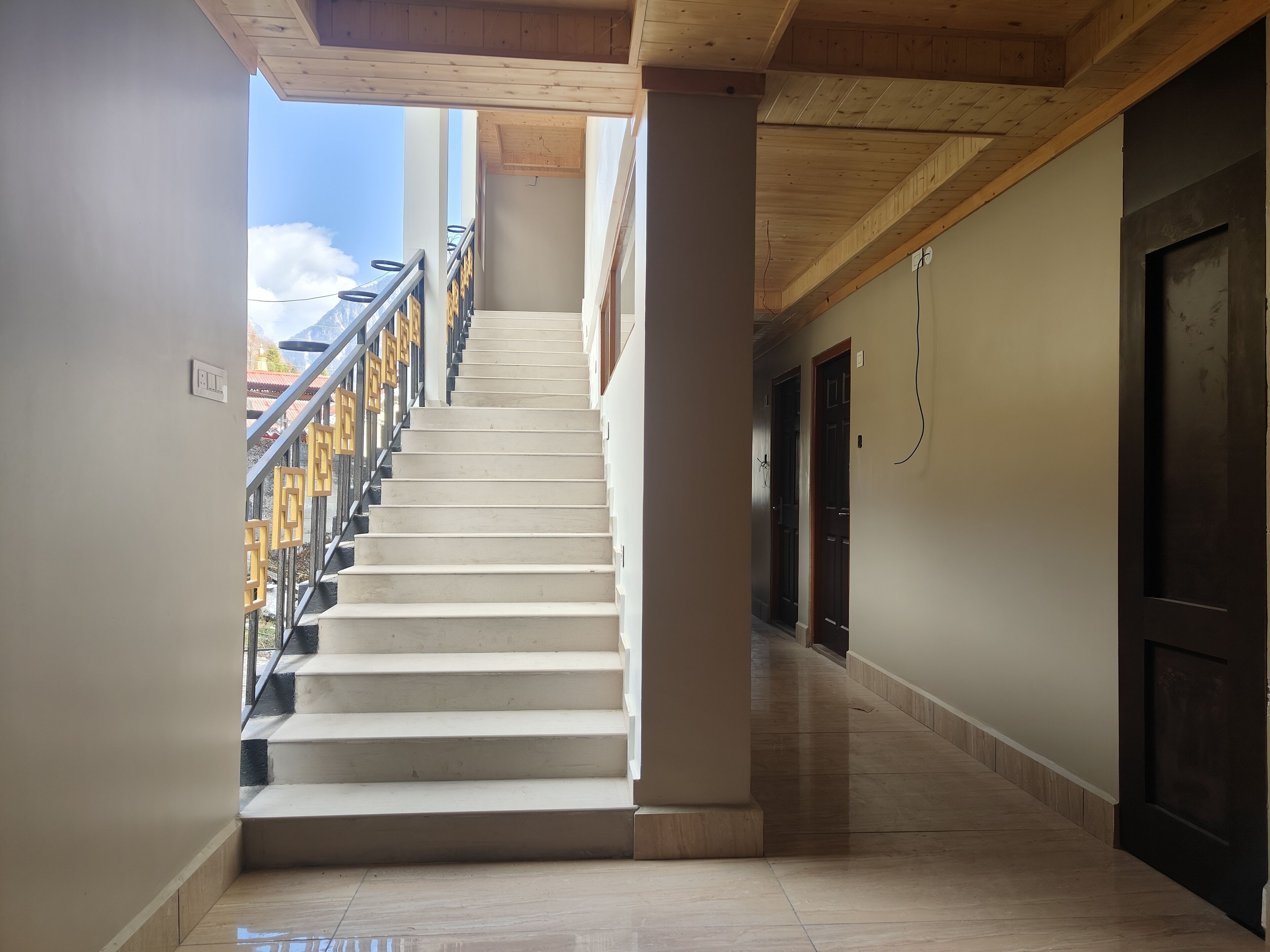 A staircase leading to a balcony with a view of mountains.