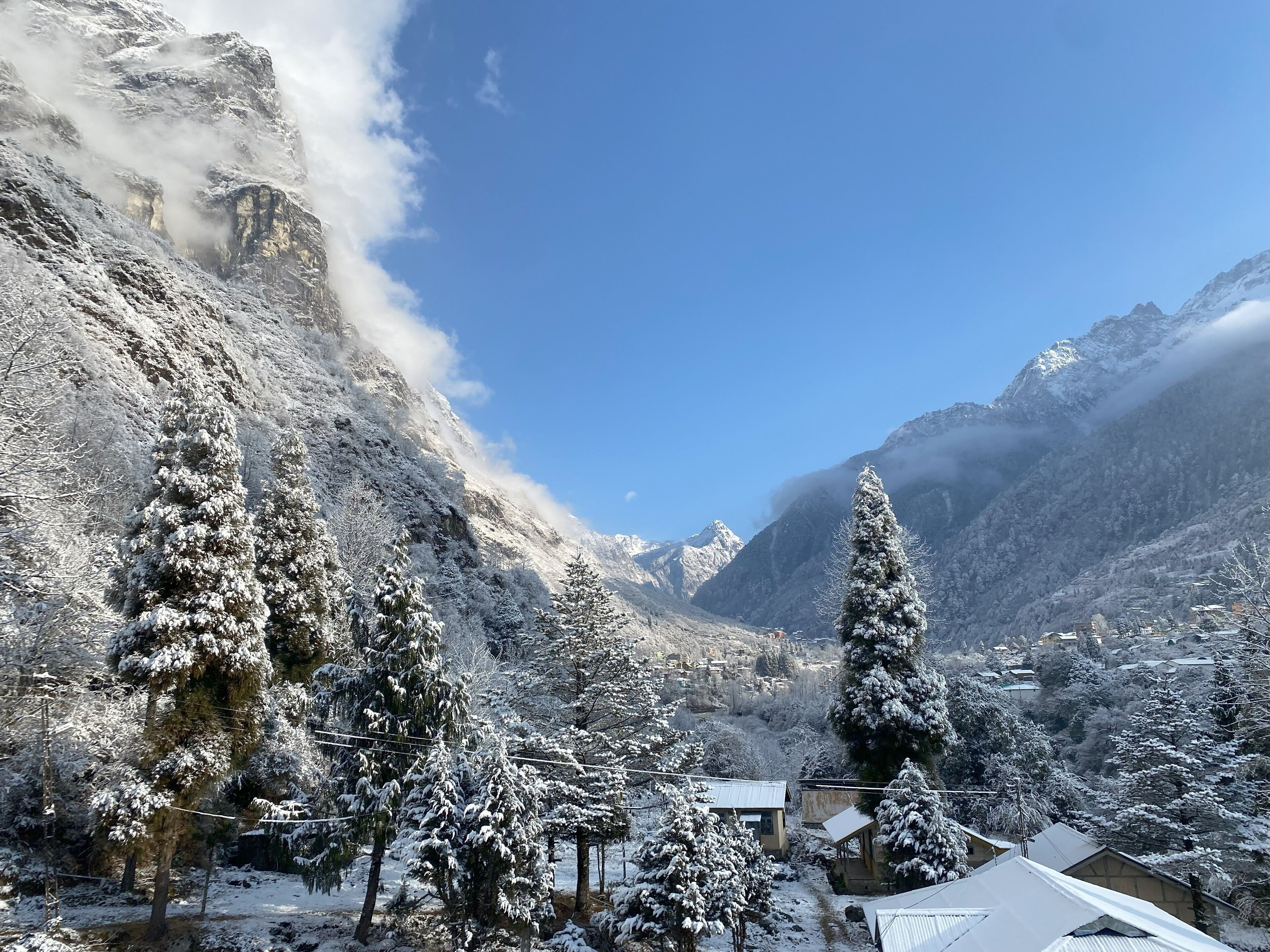 A mountainous landscape with snow-covered trees and buildings.