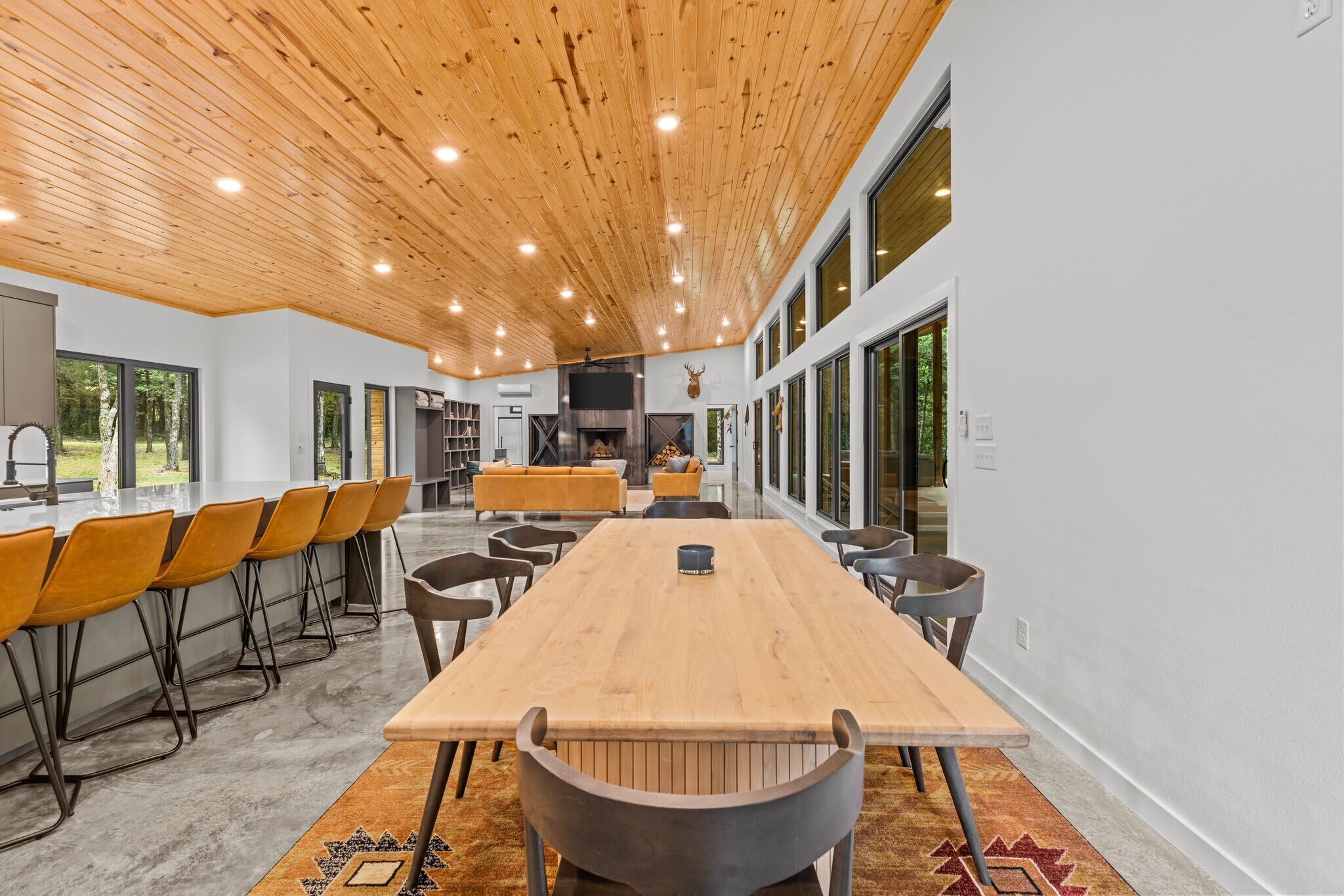 A spacious room with a long wooden table, multiple chairs, and a fireplace.