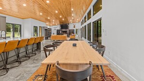 Una habitación amplia con una larga mesa de madera, varias sillas y una chimenea.