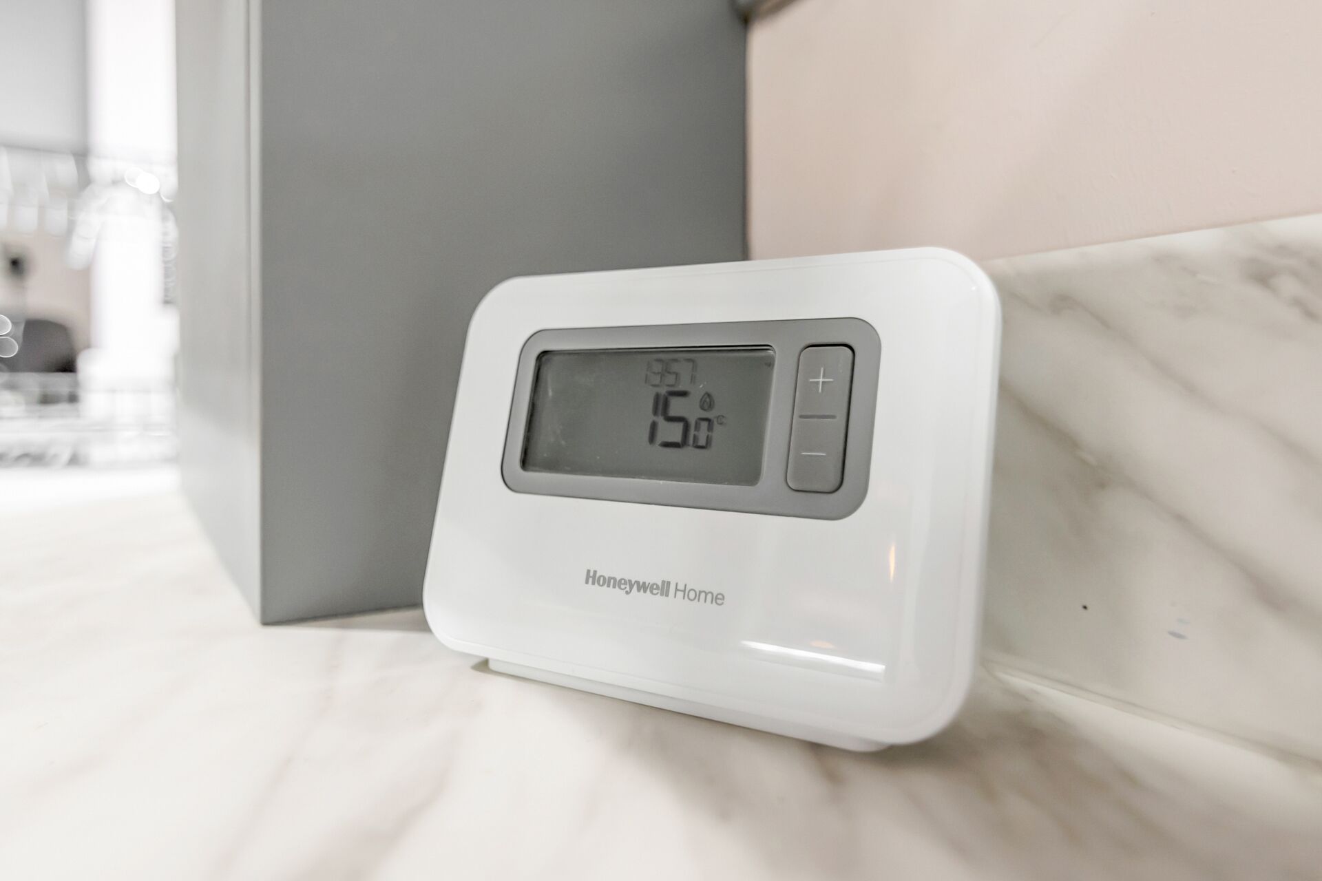 Un termostato Honeywell sobre una encimera de mármol.