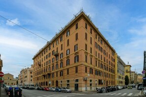 A large, multi-story building with a classic architectural style, featuring a prominent corner entrance and multiple windows. - Candia Cento Apartment Vatican Museums (Rome)