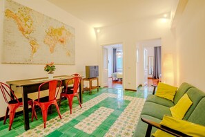 A dining area with a table, chairs, and a world map on the wall. - Candia Cento Apartment Vatican Museums (Rome)