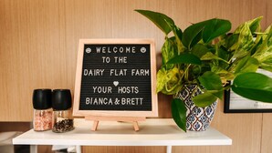 A welcome sign at a farm, a potted plant, and two salt shakers. - Kiwi Farm Cabin 2 by Tiny Away (Waitoki)