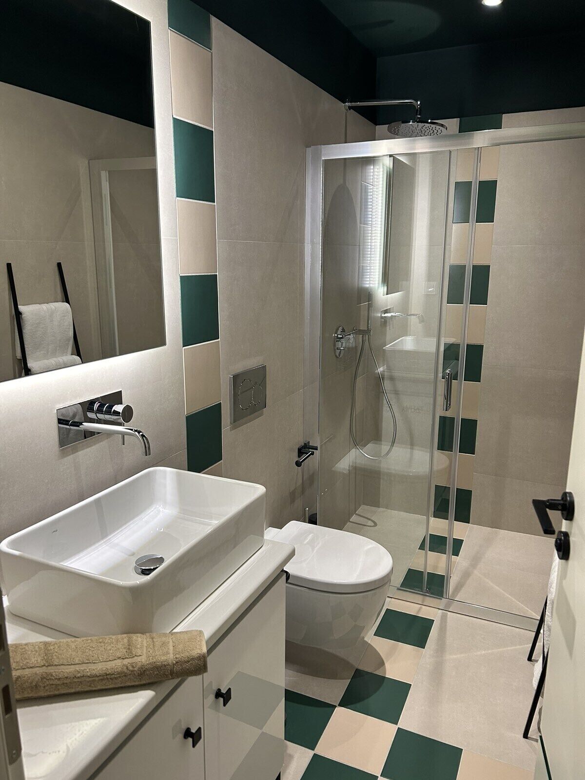 Ein modernes Badezimmer mit Duschkabine aus Glas, einem weißen Waschbecken und einer Toilette.