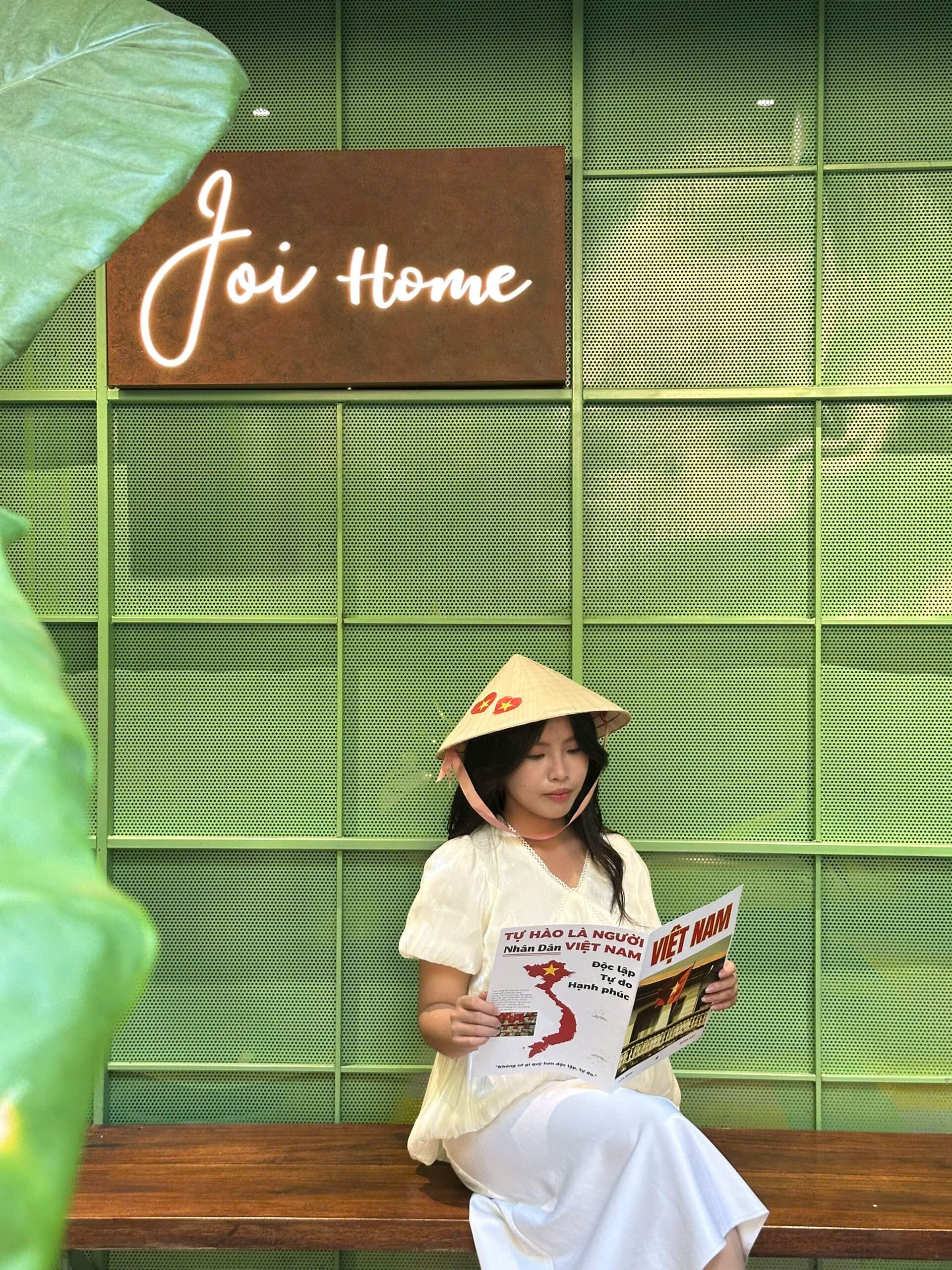 A person sitting on a bench with a sign reading 'Joie Home' in the background.