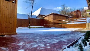 A wooden building with a snow-covered roof and a wooden deck.