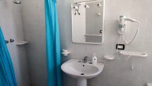 A bathroom with a white sink, a mirror, a handheld showerhead, and a towel rack. - La Palma Residence Two Bedroom Apartment (TORRE SAN GIOVANNI)